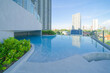 © tampatra - Swimming pool on rooftop of hotel apartment building in Bangkok downtown skyline, urban city view. Relaxing in summer season in travel holiday vacation concept. Recreation lifestyle.