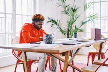 Poster - african american male student sitting at desktop with education equipment for learning and using cel