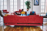 Fototapeta  - Youthful couple in love talking and discussing plans during weeknd time in apartment, Turkish boyfriend communicating with Caucasian girlfriend resting at cozy sofa in stylish living room