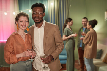 Wall Mural - Waist up portrait of elegant young couple looking at camera while enjoying party at home, copy space