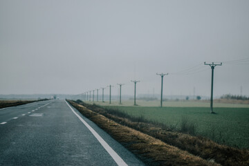 Wall Mural - Misty long road among the field in a springtime