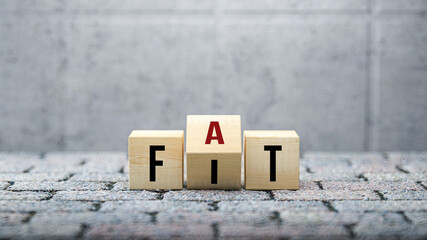 fat versus fit concept with words on wooden blocks with revolving letter depicting options, choices 