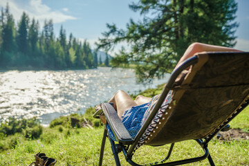 Poster - one person relaxing in the camping chair on the beach of river