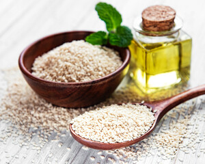 Sticker - Sesame oil and seeds on a rustic table.