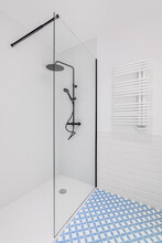 Bathroom Decorated With Light Blue And White Tiles. Modern Shower Zone With Big Rain Head, Hand Held Shower And Glass Door