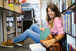 © NDABCREATIVITY - Education, high school, university, learning concept. Smiling student girl reading book at library