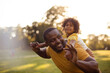 © liderina - African American father and daughter having fun outdoors.