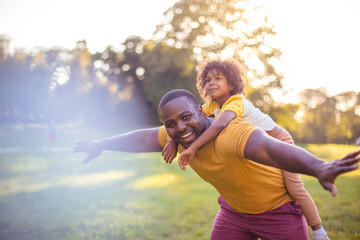 Wall Mural - African American father and daughter having fun outdoors.