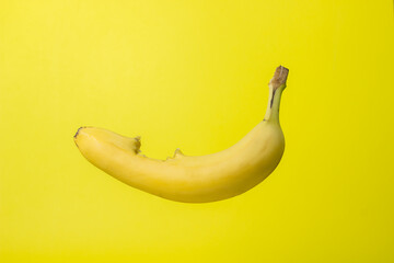 Poster - Banana on a yellow background. Bright fruit. Bitten banana with peel