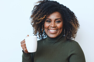 Wall Mural - Smiling adult African American woman with curly hair holding a white cup