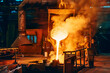 Pouring molten metal into mold from ladle container in foundry metallurgical factory workshop, iron cast, heavy industrial background.