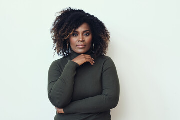 Thoughtful African American Woman with curly hair Looking At Camera with hand on chin