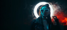 Cyberpunk People. Futuristic Banner. Urban Fashion. Blue Neon Light Asian Girl In Glasses With Glowing LED Circle Halo In Red Color Smoke Isolated On Dark Night Copy Space Background.