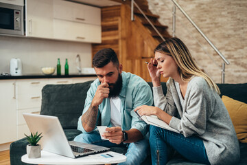 Wall Mural - Couple using a laptop while working on their home finances