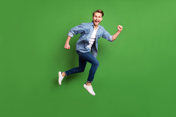 Sticker - Full length body size side profile photo of young guy jumping running fast isolated bright green color background