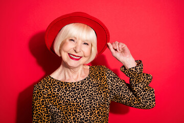 Sticker - Photo of cheerful nice lovely old woman hold hand wear hat smile good mood lady isolated on red color background