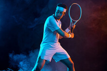 Tennis Player With Racket In White T-shirt. Man Athlete Playing On Dark Background.