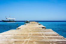 Sailboats On Pier By Sea Against Clear Blue Sky