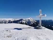 Cross On Snowcapped Mountain Against Blue Sky