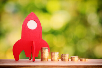 Concept image of coins stack and red rocket symbolling growth and profit