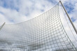 Detail eines Ballfangnetzes an einer Sportanlage vor blauem Himmel  und Wolken