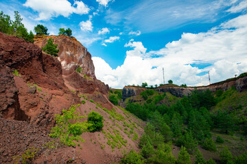 Wall Mural - visiting the extinct volcano we climb the reddish rocks covered with green vegetation