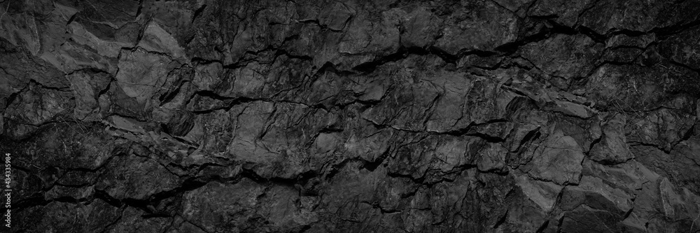 Volumetric rock texture with cracks. Black stone background with copy space for design. Wide banner. - obrazy, fototapety, plakaty 