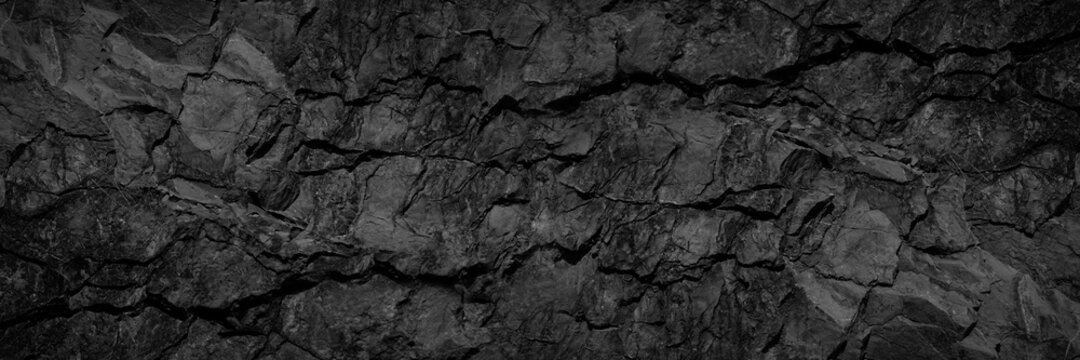 Wall Mural -  - Volumetric rock texture with cracks. Black stone background with copy space for design. Wide banner.