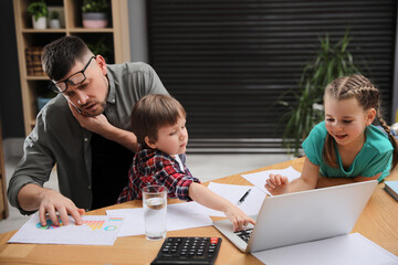 Overwhelmed man combining parenting and work at home