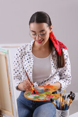 Poster - Happy woman artist drawing picture on canvas indoors