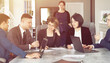 © Maksim Selin - Group of young successful businessmen lawyers communicating together in a conference room while working on a project
