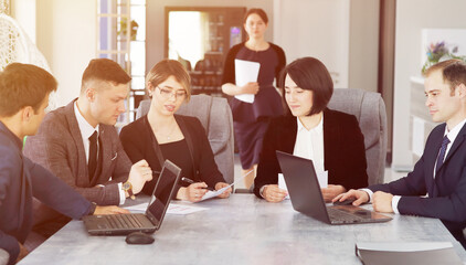 Wall Mural - Group of young successful businessmen lawyers communicating together in a conference room while working on a project