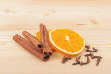 Cinnamon, Cloves And A Slice Of Dried Orange On A Wooden Background