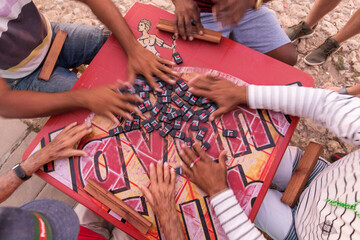 Peoples hand on a table playing domino in the street of Trinidad, Cuba