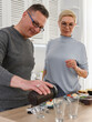 © woodpencil - A healthy sporty senior couple takes food supplement protein from shaker before dinner. Active lifestyle for retirees