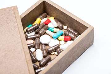 Prescription drugs of different shape and color in open pill box isolated on white, pillbox