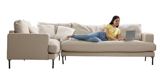 Wall Mural - Young woman with laptop on comfortable sofa against white background