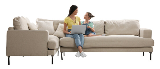 Canvas Print - Young woman and her daughter with laptop on comfortable sofa against white background