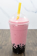 Strawberry banana boba smoothie served cold with a thick straw for the tapioca balls to easily pass.