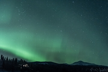 mountain view landscape in northern canada with aurora borealis seen northern lights dancing in gree