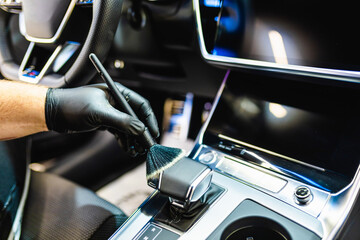 A man cleaning car interior, car detailing (or valeting) concept. Selective focus..