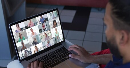 Poster - African american man having a video conference with office colleagues on laptop at home