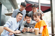 © imtmphoto - group of young asian adults looking at cellphone together