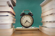 Alarm clock and book  with blackboard background