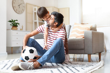 Wall Mural - Father and little son with soccer ball at home