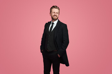 Stylish businessman in suit on pink background in studio