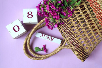 Wall Mural - Calendar for June 8: cubes with the numbers 0 and 8, the name of the month of June in English, wicker basket and a bouquet of purple flowers, pastel background, top view