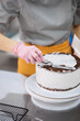 © Anischenko - A bright pastry chef girl is engaged in the preparation of a cake