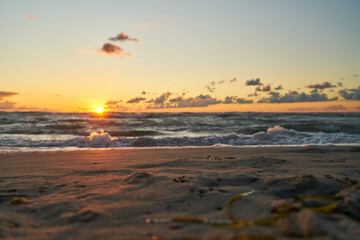 Wall Mural - Sand on the beach at sunrise on the ocean with waves