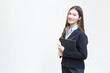 © nut_foto - Asian business  woman in black suit smiles happily while she works and holds tablet on white background.